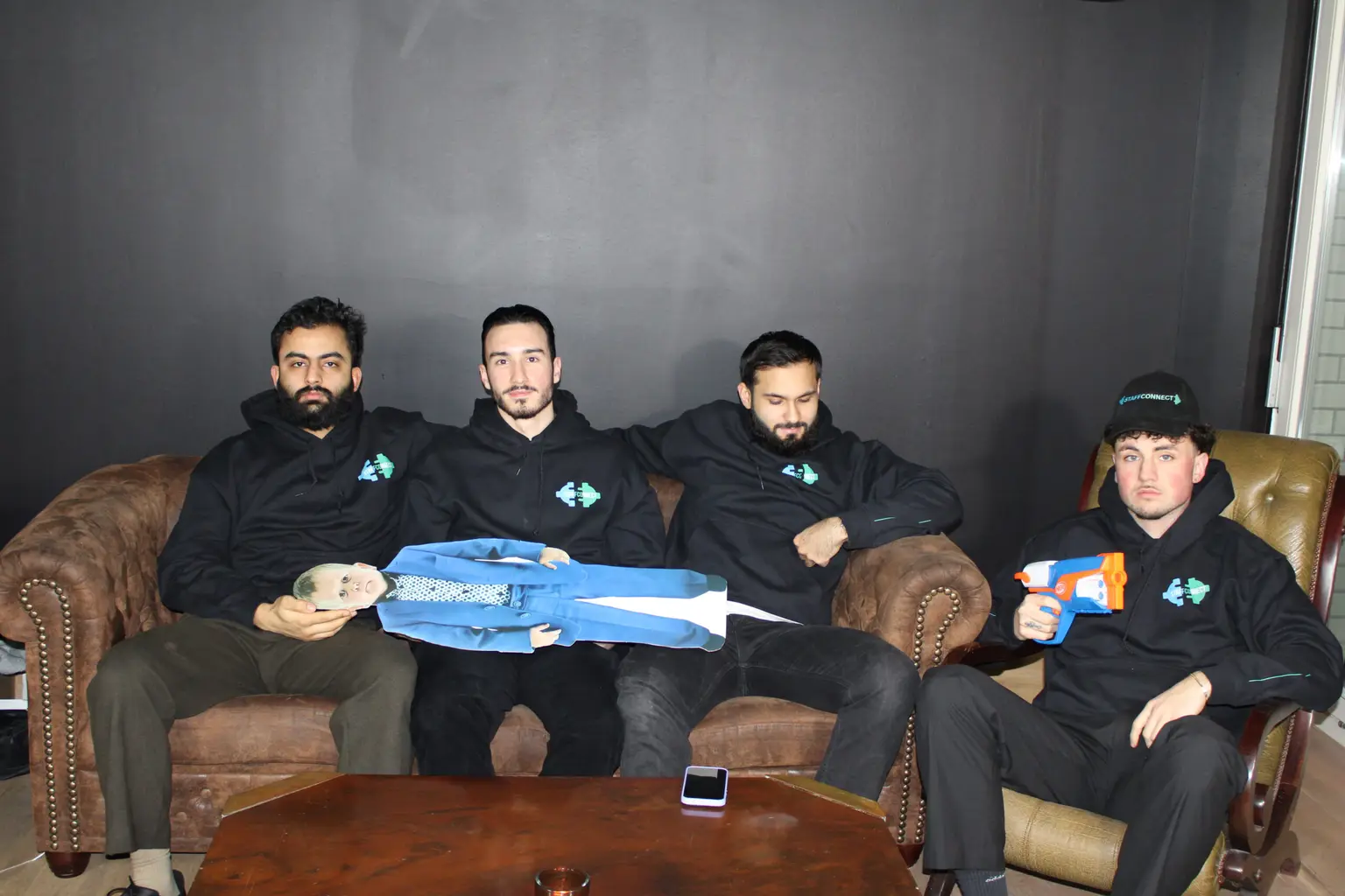 Crew in Marken-Hoodies mit Requisiten auf Sofas in einer Drehpause – Personal für Film und Produktion in Berlin