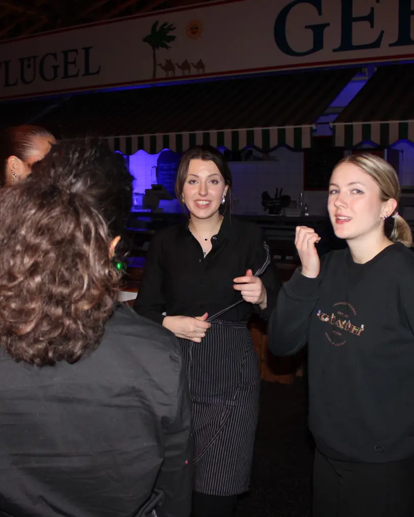 Team in Marken-Hoodies im Abendbetrieb einer Markthalle