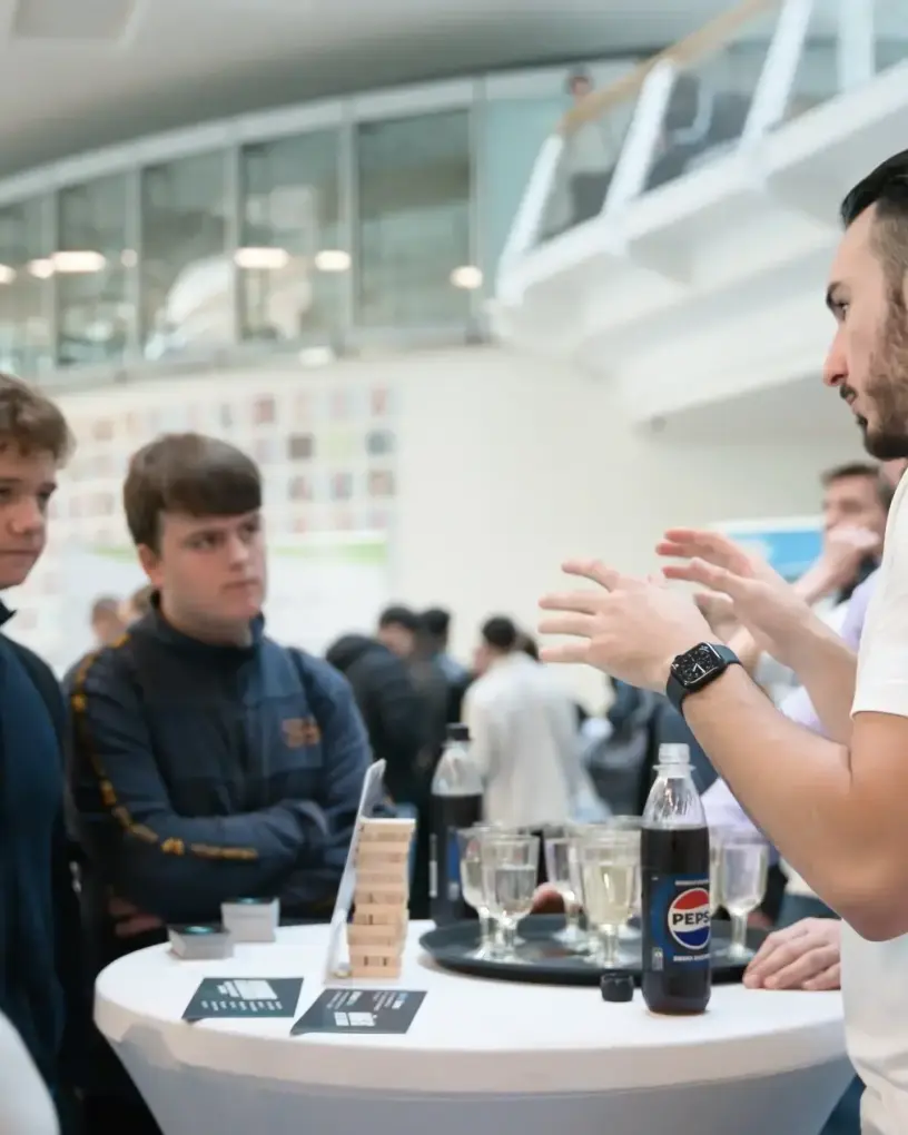 Promoter am Stehtisch im Foyer, Produkte auf dem Tisch, Gespräch mit Besuchern