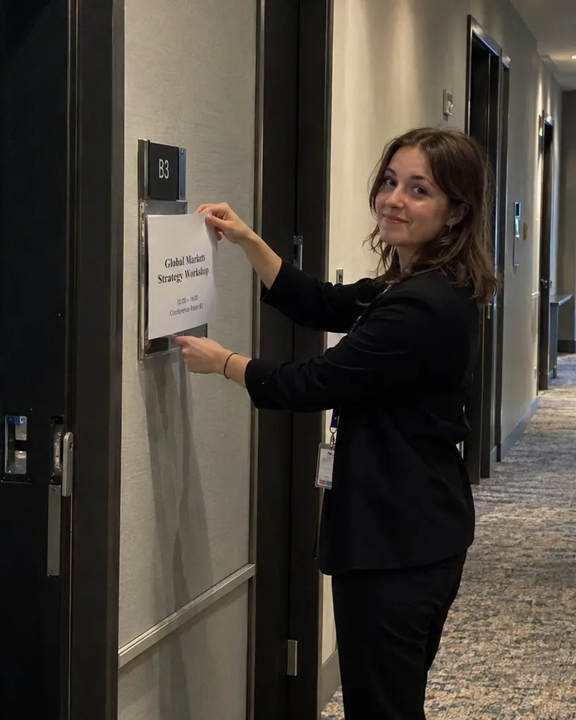 Hostess tauscht im Flur eines Tagungshotels das Raumschild für den nächsten Workshop aus – Serviceroboter mieten in Berlin