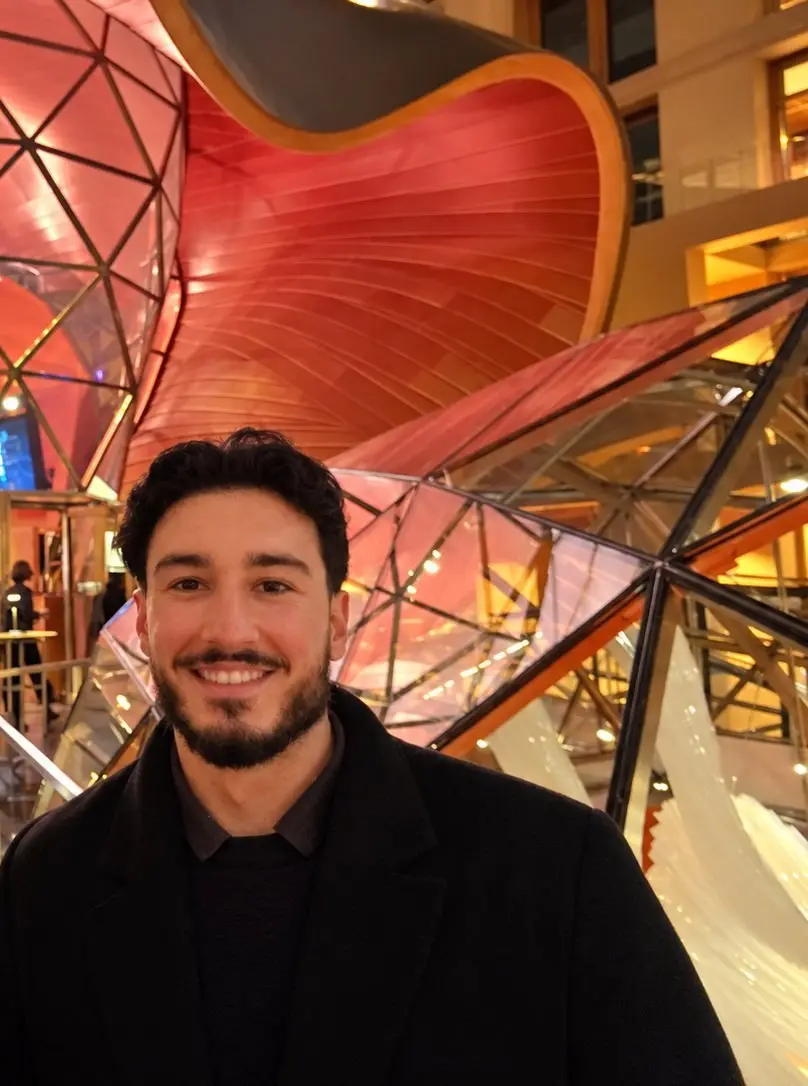 Leon Chiosea, founder and owner of StaffConnect, smiling in front of red-lit, curved architecture