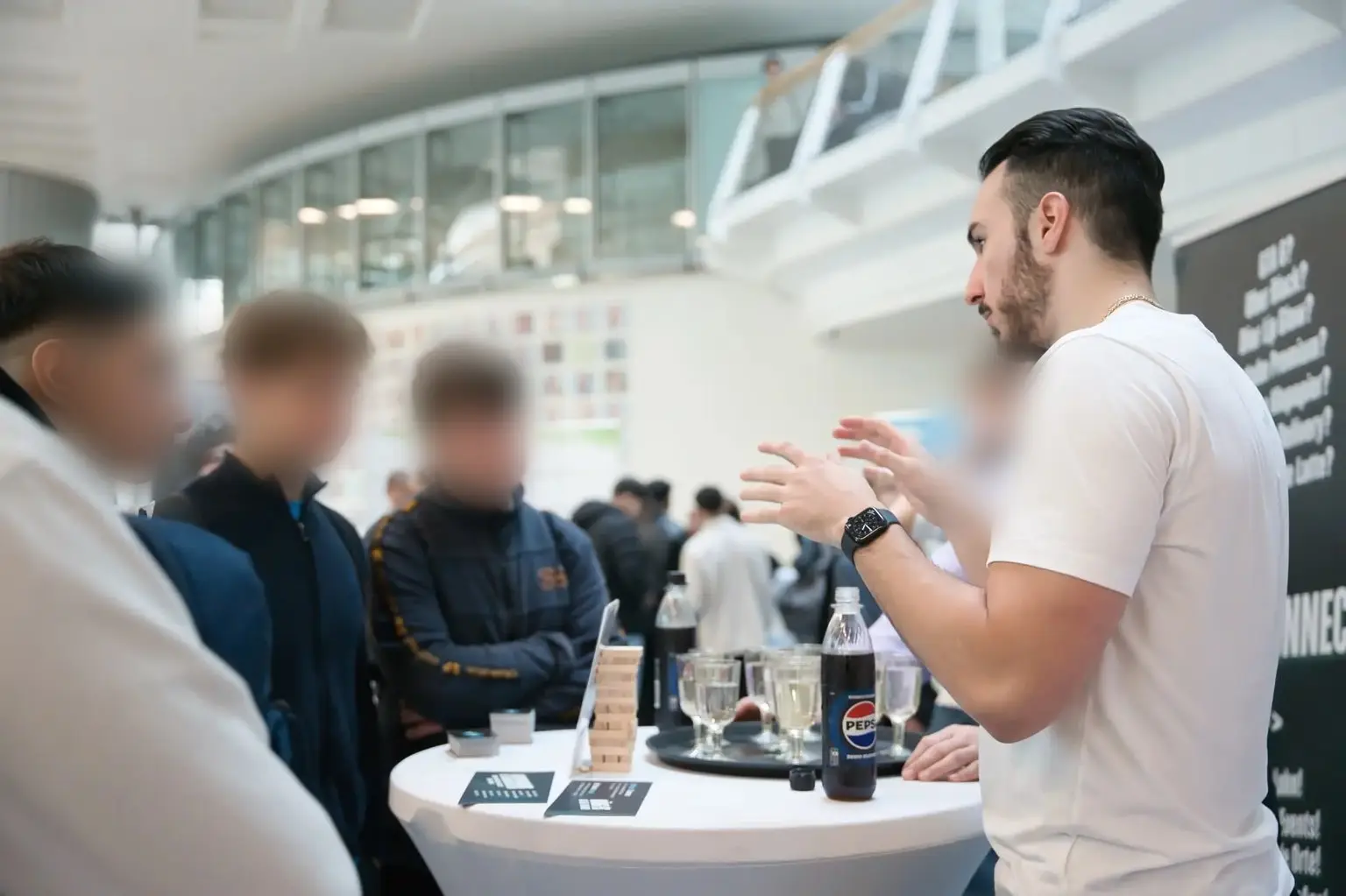 Gründer Leon Chiosea im Gespräch mit Interessierten an einem Stehtisch, die Gesichter der anderen sind unkenntlich gemacht
